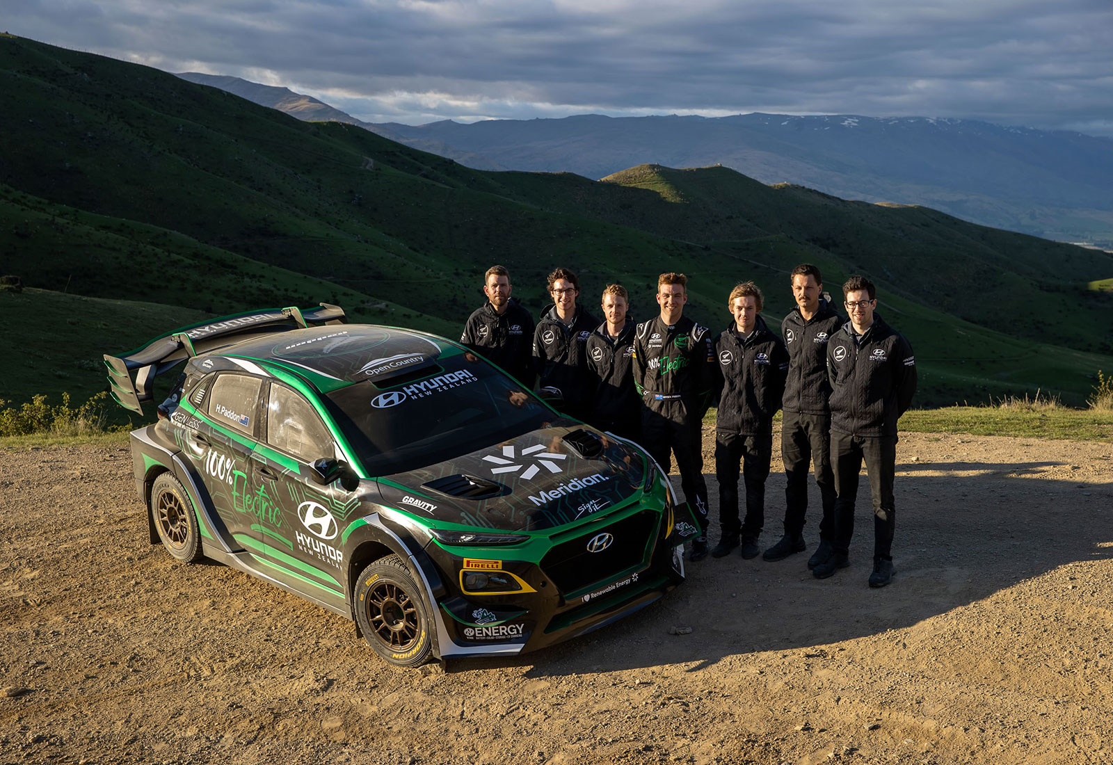 Paddon Rally Sport team standing with Hayden Paddon's electric rally car. 